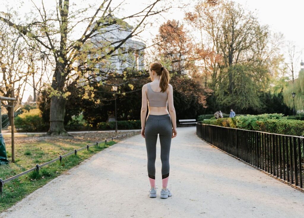 Liposuction sonrası ilk haftalarda parkta hafif tempolu yürüyüş yapan kadın